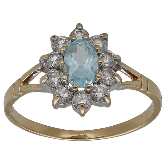 Gold cocktail ring with blue topaz center and sparkling clear CZ cluster halo