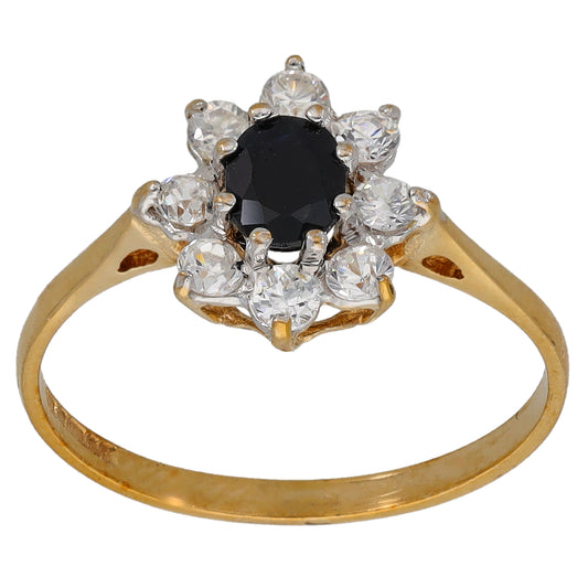 Gold dress ring with black center stone and clear cubic zirconia halo, round setting