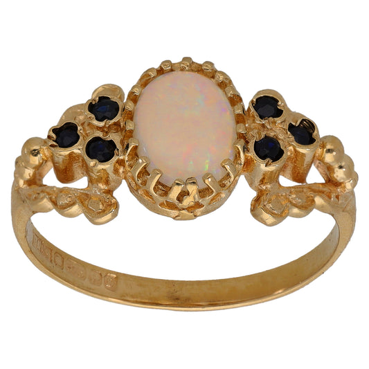 9ct gold ring with oval opal center, claw-set dark sapphire accents, size Q