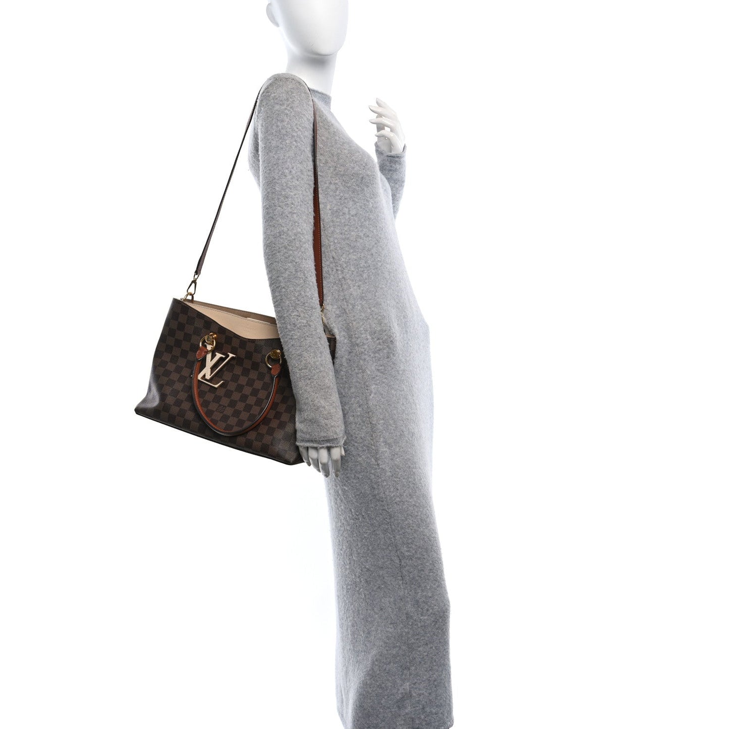 Mannequin wearing a gray outfit with a brown checkered handbag on a white background