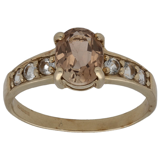Gold-tone ring with large oval smoky center stone and small clear side accents