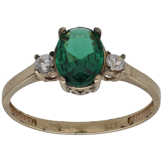 Gold-tone ring with green oval center stone and two clear round accent stones