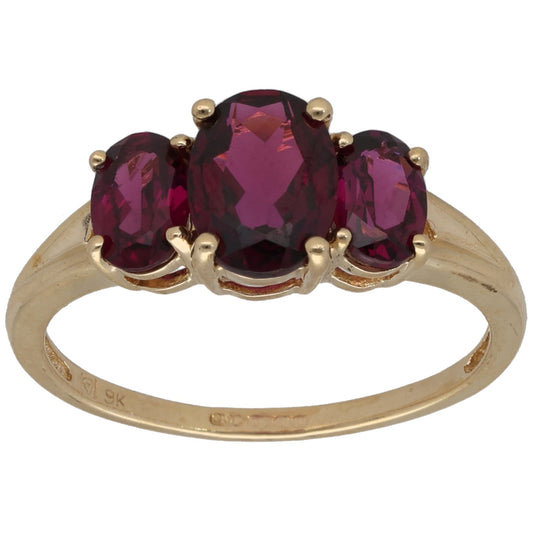 Gold three-stone garnet ring with oval center and two marquise stones, prong-set