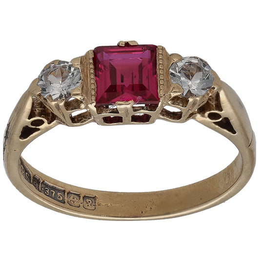 Gold single-stone ring with square red center and two clear round accents