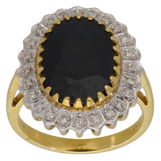 Gold cocktail ring with oval dark gemstone and diamond-like halo, scalloped edge