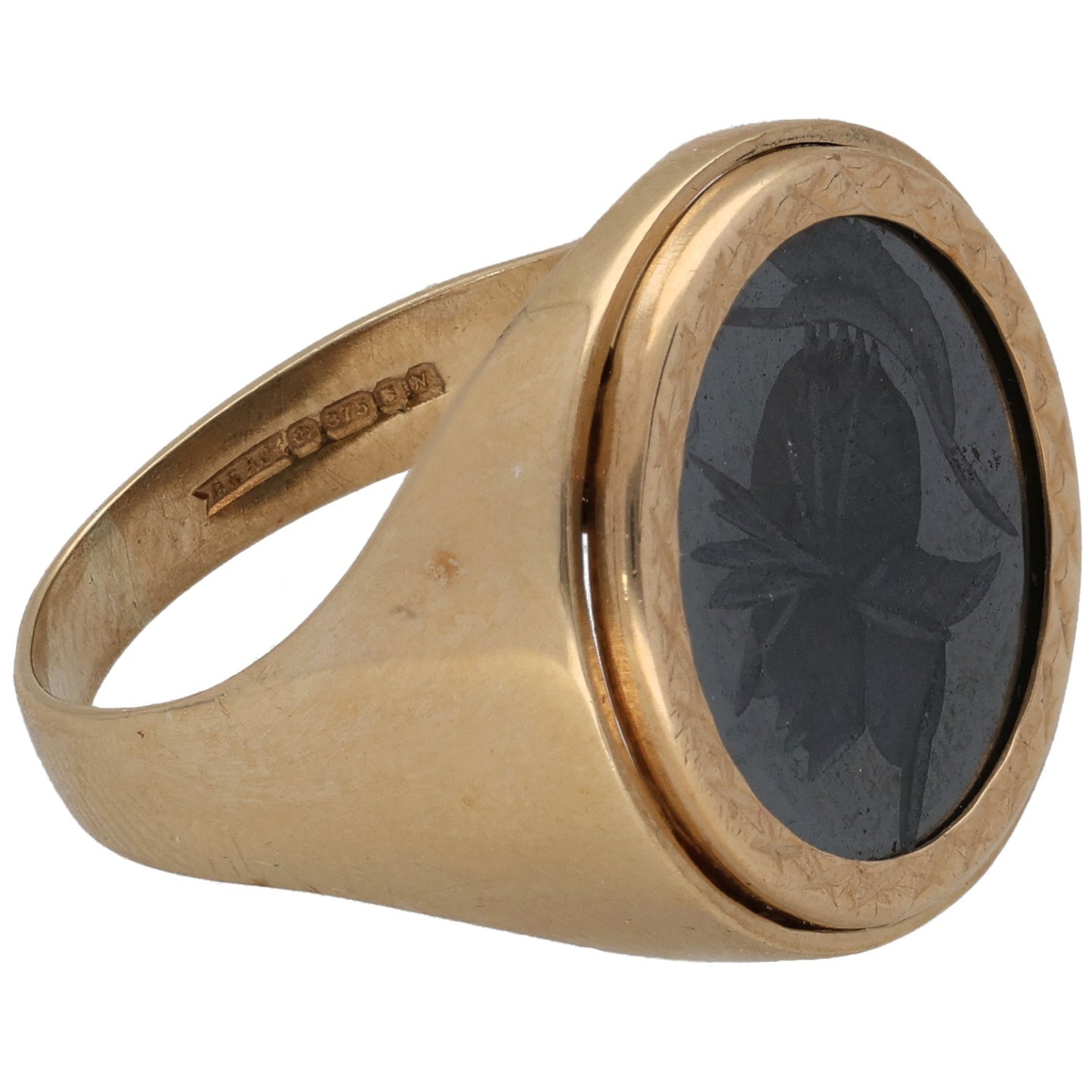 Gold signet ring with dark oval stone, leaf engraving, and wide band