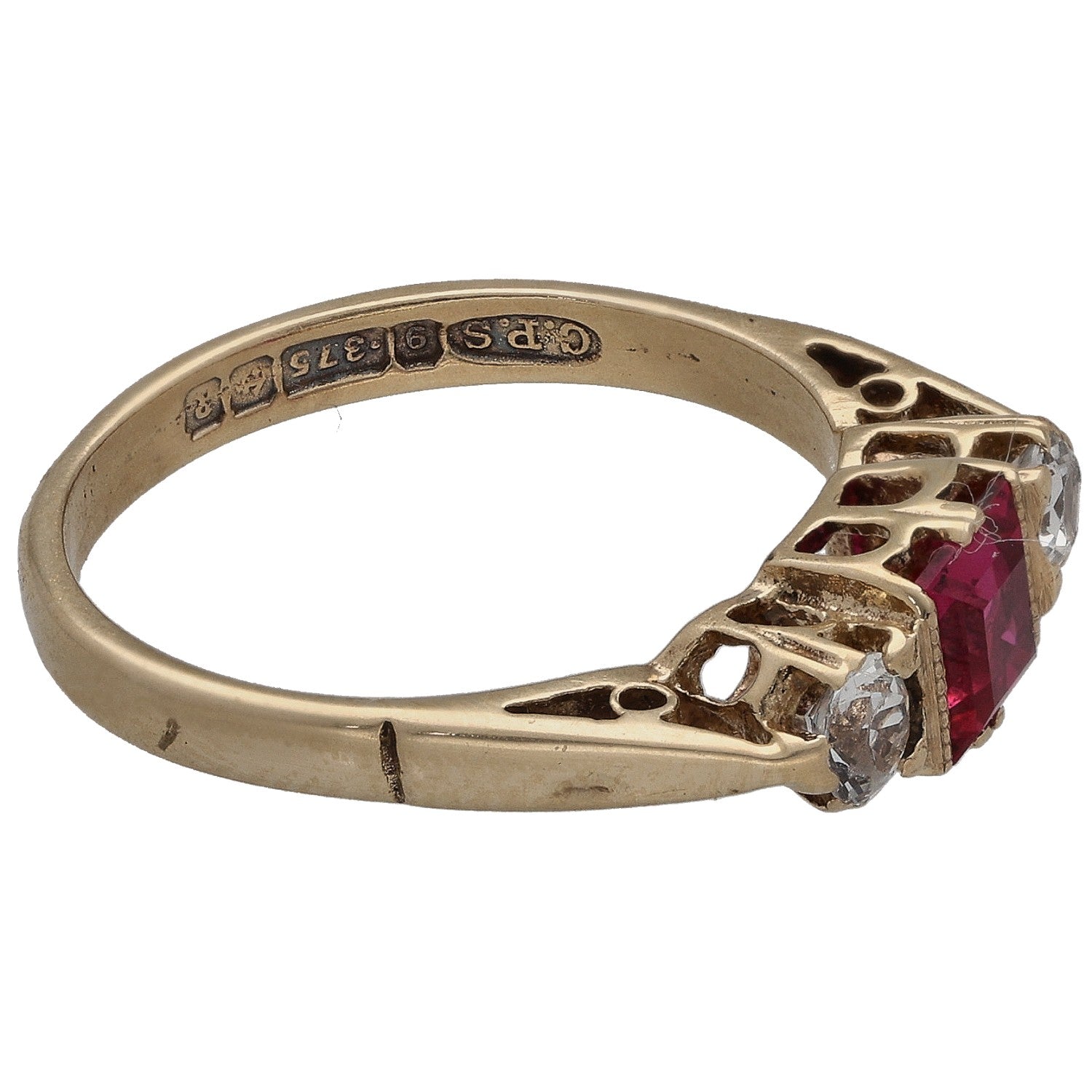 Gold ring side view with red square stone and clear round accents in prongs