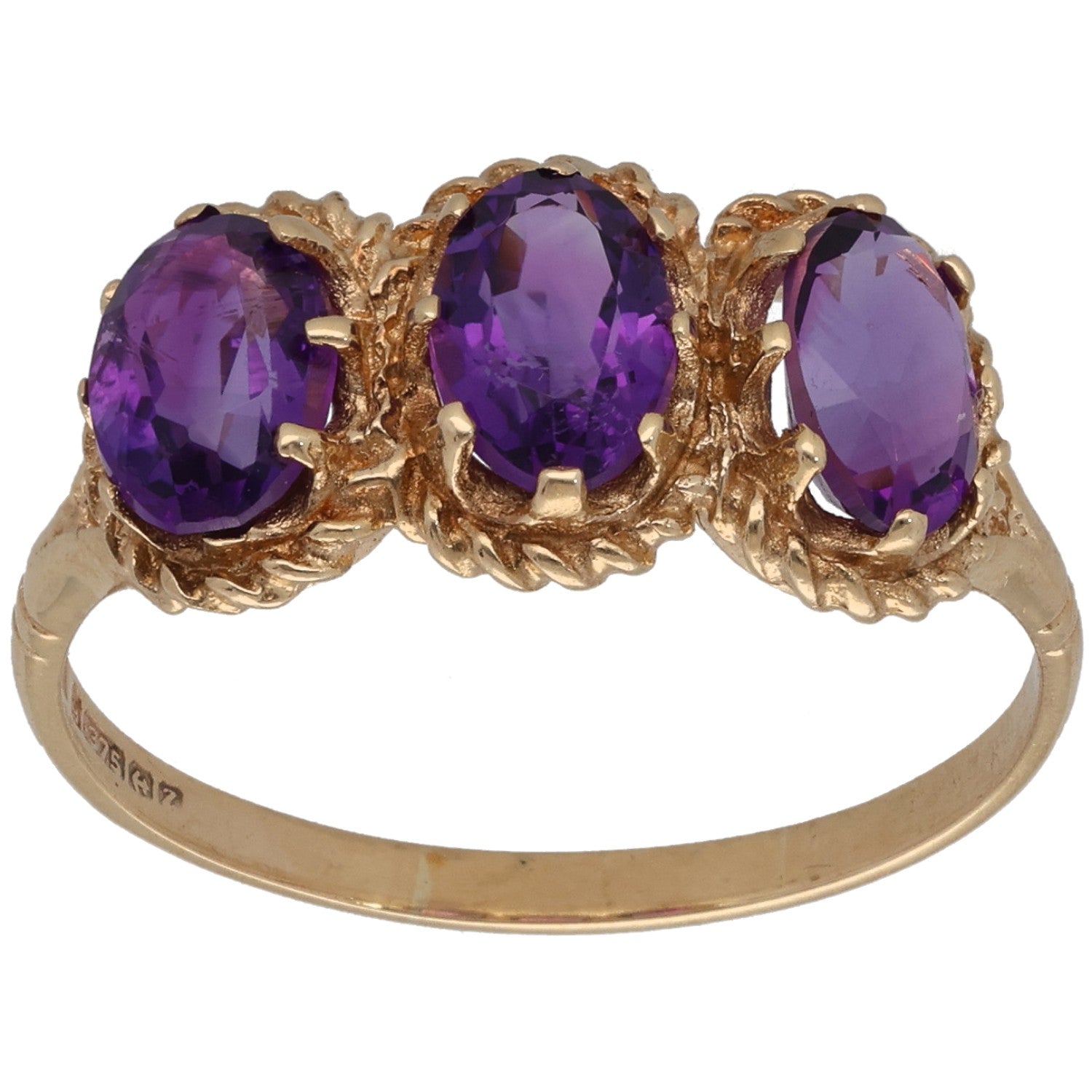 Gold three-stone amethyst ring with three oval purple gemstones in ornate setting