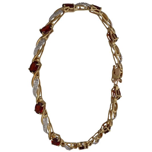 Gold link bracelet with alternating round red garnet stones and diamond accents.