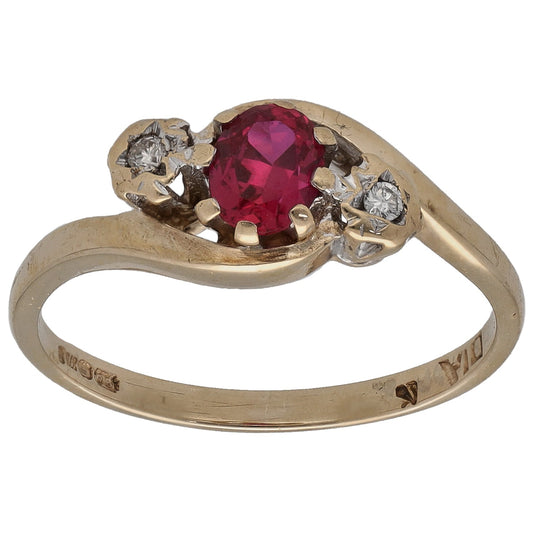 Gold three-stone ring with round deep red center stone and two small round diamonds