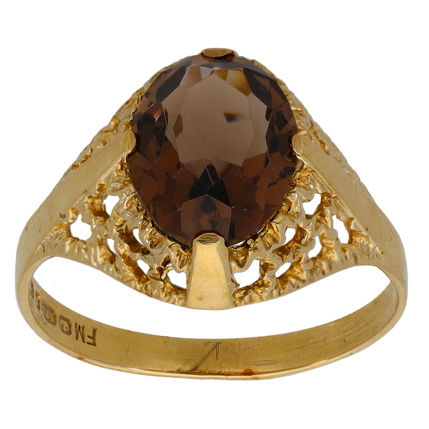 Gold ring with large faceted dark gemstone and ornate openwork shoulders