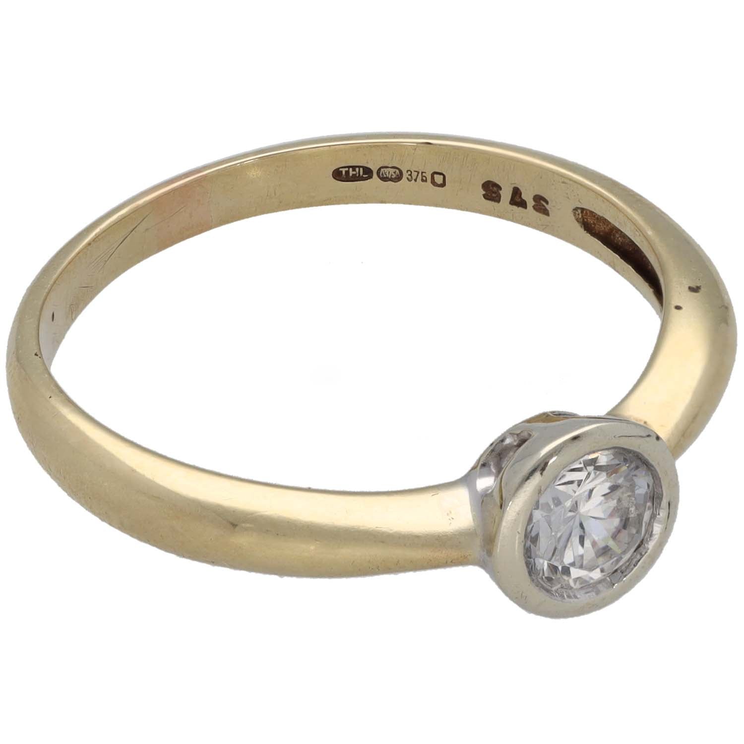 Gold-tone ring with round CZ solitaire and silver-toned bezel setting, side view