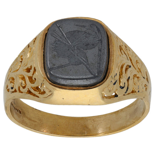 Gold signet ring with oval dark hematite crest stone and carved gold emblem