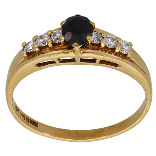 Gold-tone ring with large oval black center stone and clear round side stones
